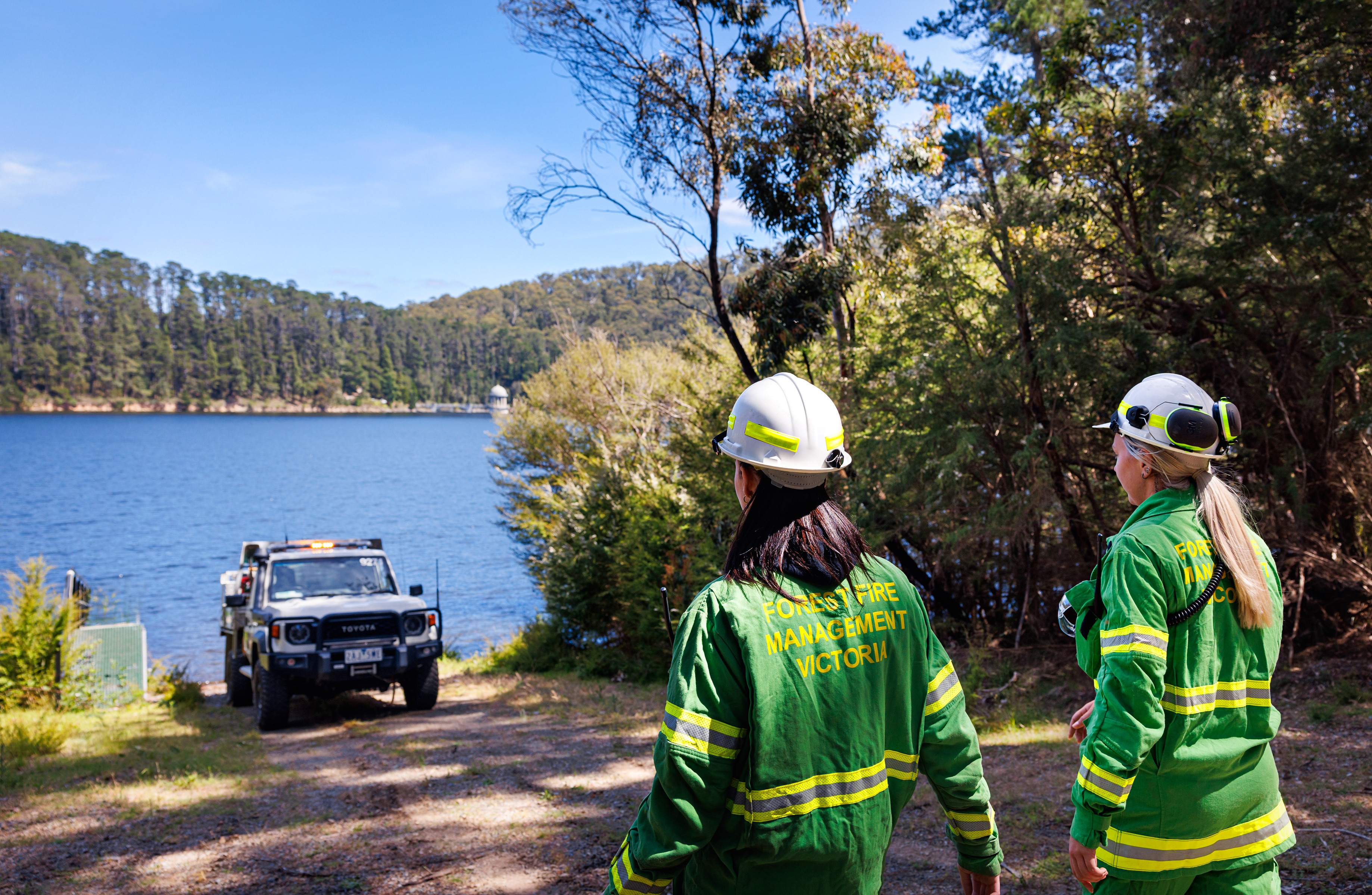 Melbourne Water firefighters with a truck looking over to a reservoir