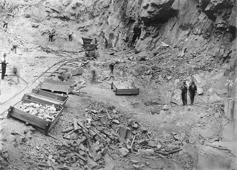 Black and white historic photo of workers moving carts