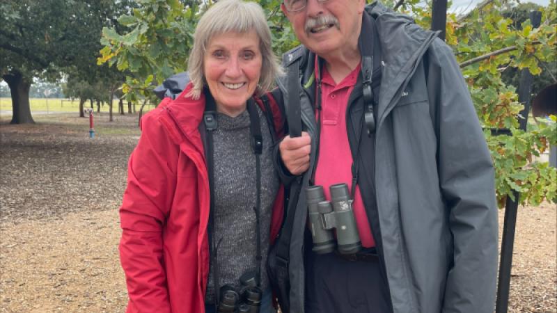 Two people standing and smiling