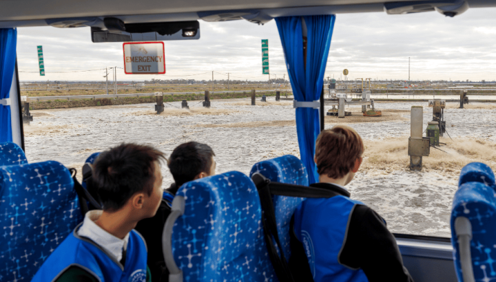 Students looking out of a bus window at the sewage treatment process