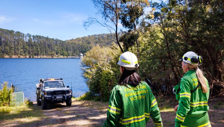 Melbourne Water firefighters with a truck looking over to a reservoir