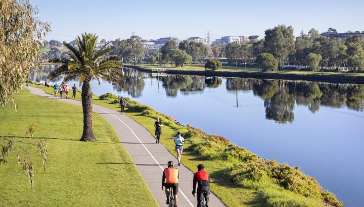 Cyclists riding along the Maribyrnong River on a clear day