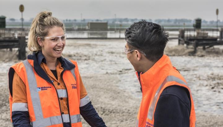 Male and female employee walking past Western Treatment Plant lagoons