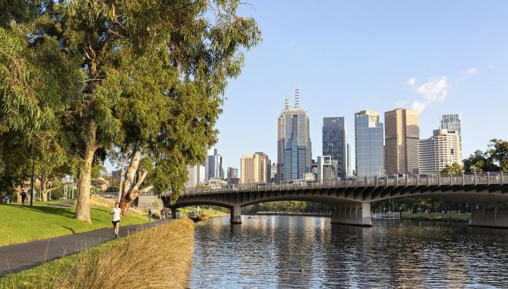 Person jogging along the Yarra River with Melbourne CBD in the background