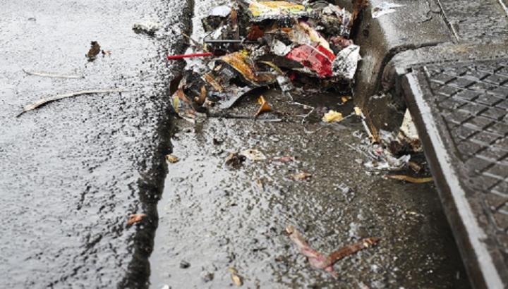Rubbish collected in a street gutter near a stormwater drain