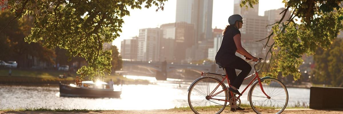 Female cyclist riding down the Yarra with city buildings in the background