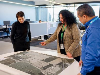 Three people looking at a printed document