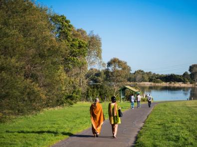 People walk along Dandenong Creek at Jells Park