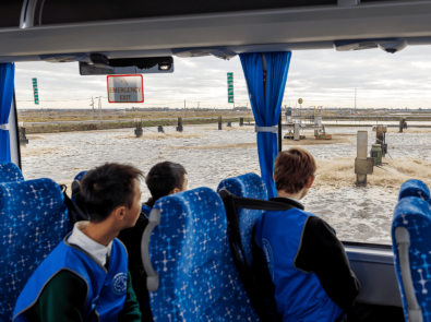 Students looking out of a bus window at the sewage treatment process