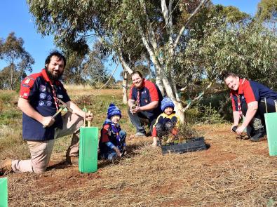 Grow West community planting day Three adults and two children planting trees