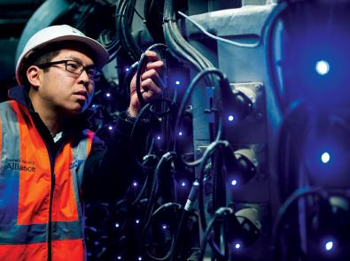 Worker inspecting a cable with blue lighting