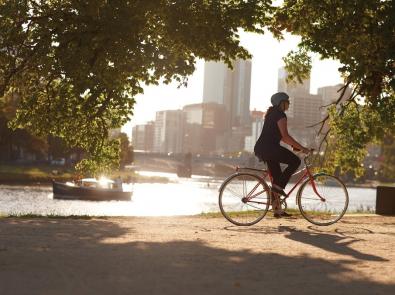 Female cyclist riding down the Yarra with city buildings in the background