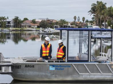 Two Melbourne Water staff members standing at Pattersons Lakes