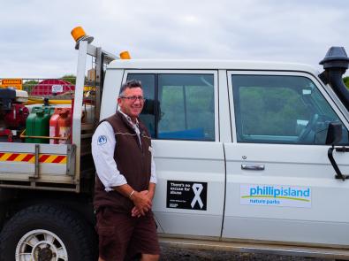 man standing next to Phillip Island Nature Parks vehicle