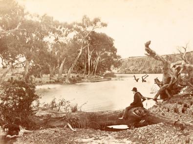 Werribee River at Werribee Park, 1879 Sepia photograph of a man in a suit sitting overlooking the Werribee River