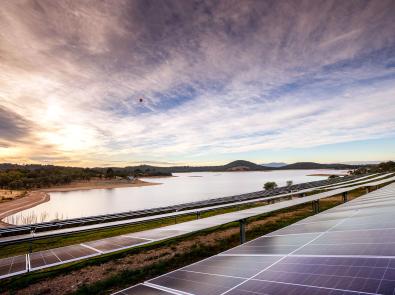 Sunrise over Sugarloaf Reservoir, with rows of solar panels in the foreground
