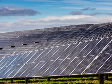 Rows of solar panels on a hill at Winneke Water Treatment Plant, partly shadowed by clouds