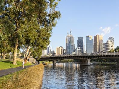 Person jogging along the Yarra River with Melbourne CBD in the background