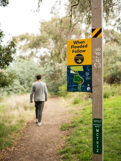 Man walking past a flooding sign near Ceres