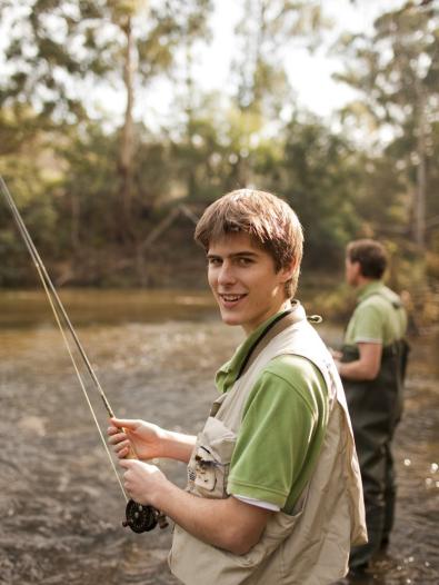 Fishing Boy and man fishing by a river