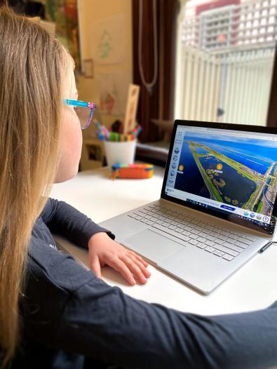 Primary school student uses virtual tour on laptop