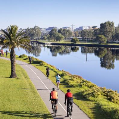 Cyclists riding along the Maribyrnong River on a clear day