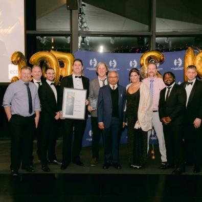 Group of people at awards ceremony posing with award