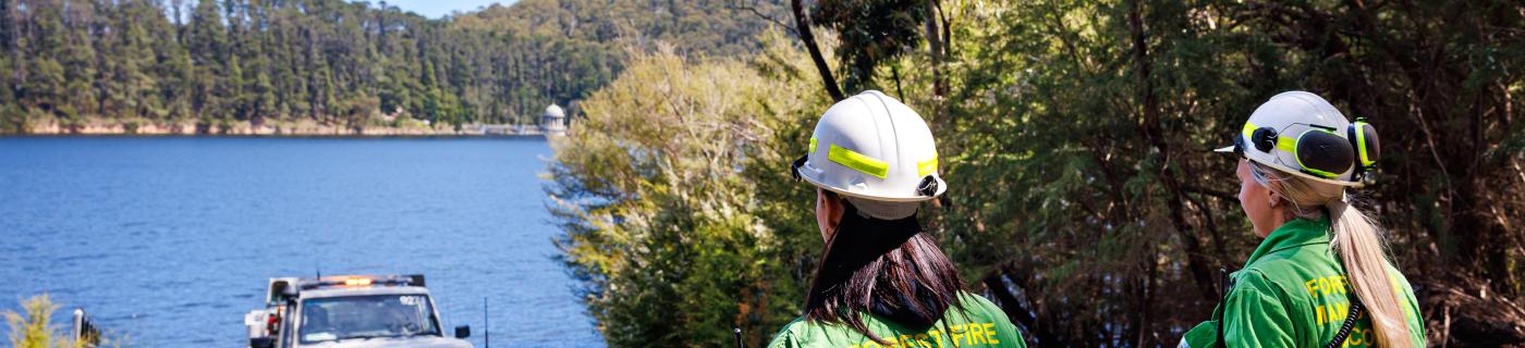 Melbourne Water firefighters with a truck looking over to a reservoir