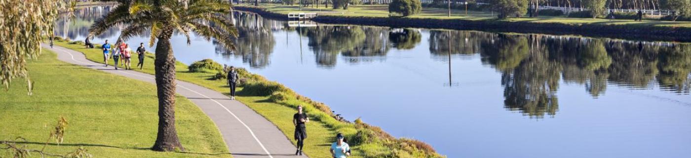 Cyclists riding along the Maribyrnong River on a clear day