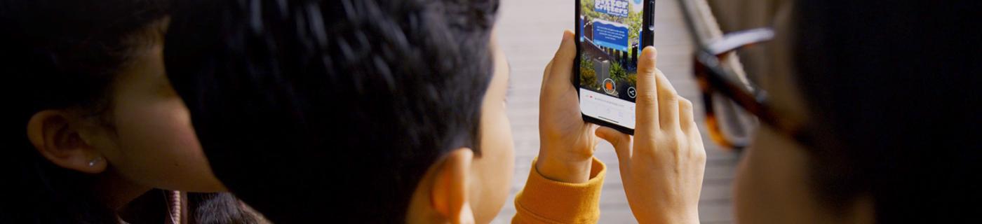 Boy holds smartphone with "Litter Critters" on the screen