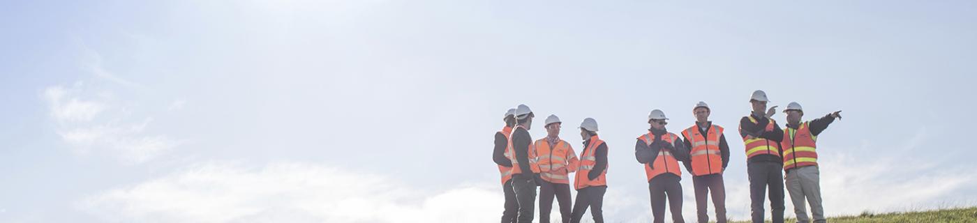 Melbourne Water workers standing on grassy site