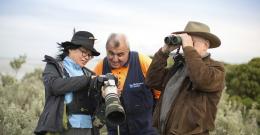 Melbourne Water employee and two people with binoculars