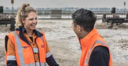 Male and female employee walking past Western Treatment Plant lagoons