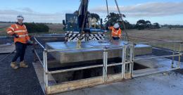 Large manhole cover being lowered onto a sewer to accommodate long range CCTV camera unit.