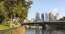 Person jogging along the Yarra River with Melbourne CBD in the background