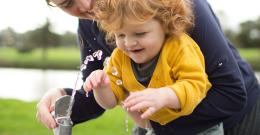 A woman and her child drink from a public water fountain