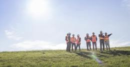 Melbourne Water workers standing on grassy site