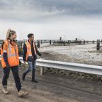Two workers walking past a site