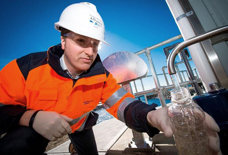 Melbourne Water employee fills a bottle with water at a treatment plant