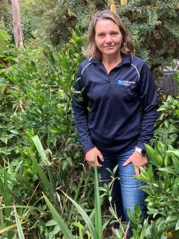 Woman in a field wearing a Melbourne Water shirt
