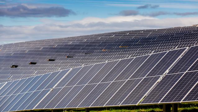 Rows of solar panels on a hill at Winneke Water Treatment Plant, partly shadowed by clouds