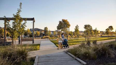 Two people walk along 'Pilot Park' in Williams Landing
