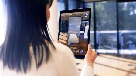 Woman holding iPad showing the app in use