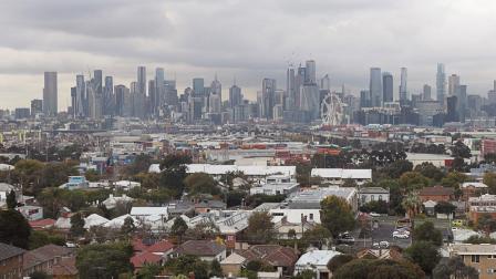 View of Melbourne CBD, with houses in the foreground and skyscrapers in the background