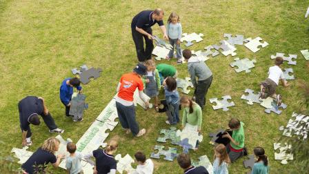 Children put together a giant jigsaw puzzle