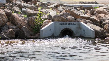 Water running out of a stormwater drain into a waterway